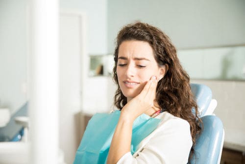 Root Canal Dentist | Woman feeling tooth pain.